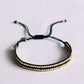Geflochtenes Armband aus schwarzen Edelsteinen und goldfarbenen Blöcken
