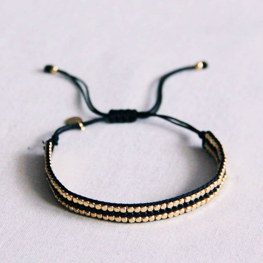 Geflochtenes Armband aus schwarzen Edelsteinen und goldfarbenen Blöcken