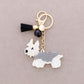 Schlüsselanhänger aus Kunstharz 'Welpe' weiß/schwarz